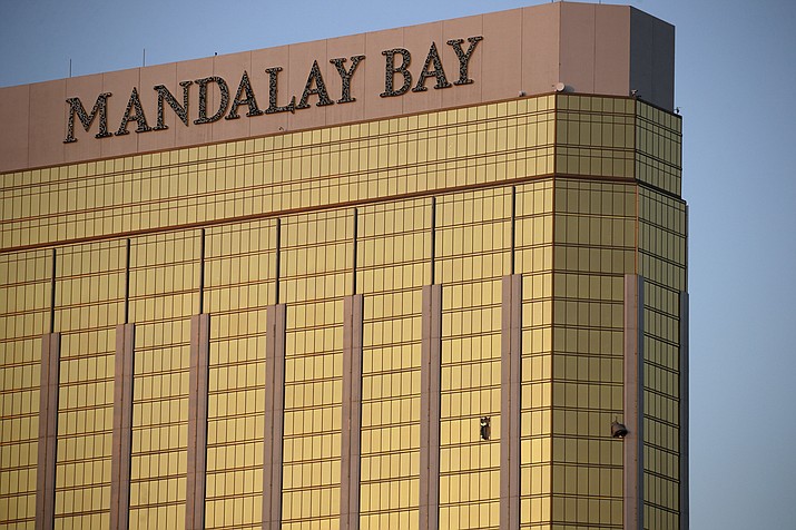 Drapes billow out of broken windows at the Mandalay Bay resort and casino Monday, Oct. 2, 2017, on the Las Vegas Strip following a deadly shooting at a music festival in Las Vegas. A gunman was found dead inside a hotel room. (AP Photo/John Locher)