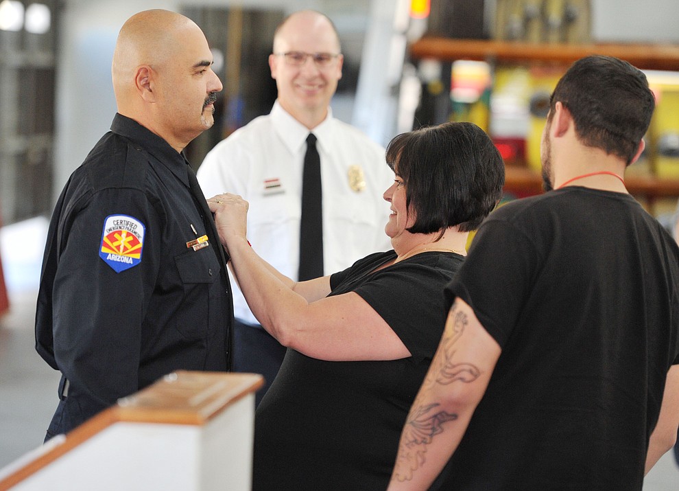 Prescott Fire Captain Allen Snyder receives his new badge from his wife Rhonda as their son Michael looks on during an Appointment and Promotion Recognition Ceremony at Station 71 in Prescott Friday, October 6. (Les Stukenberg/Courier)