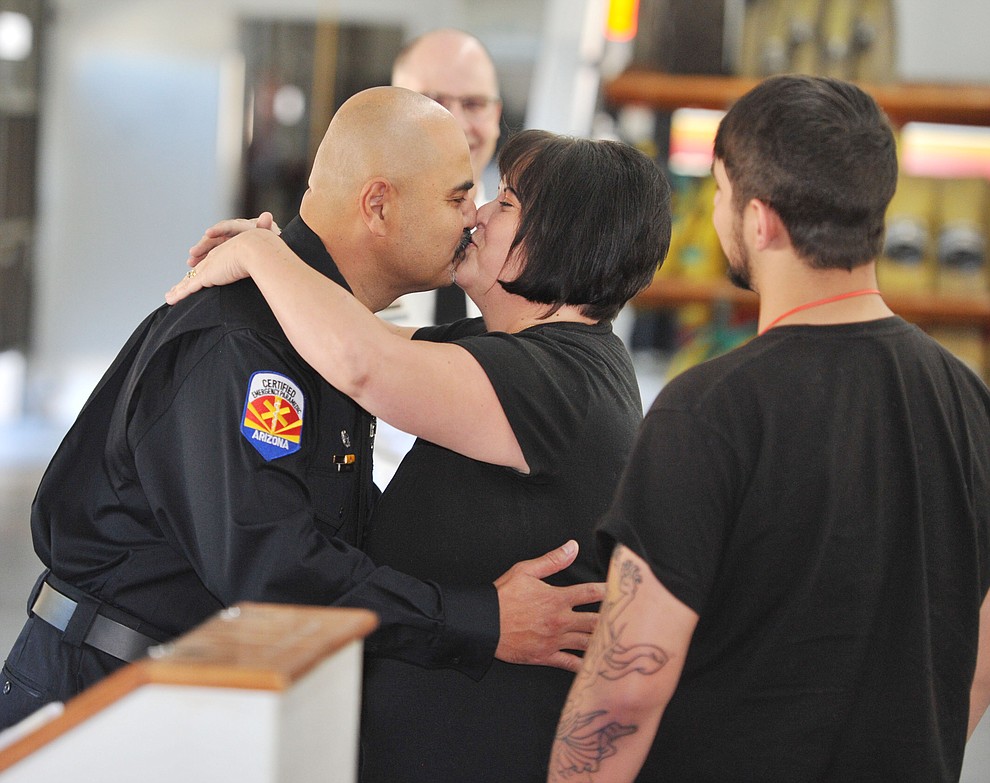 Prescott Fire Captain Allen Snyder receives a kiss after receiving his new badge from his wife Rhonda as their son Michael looks on during an Appointment and Promotion Recognition Ceremony at Station 71 in Prescott Friday, October 6. (Les Stukenberg/Courier)