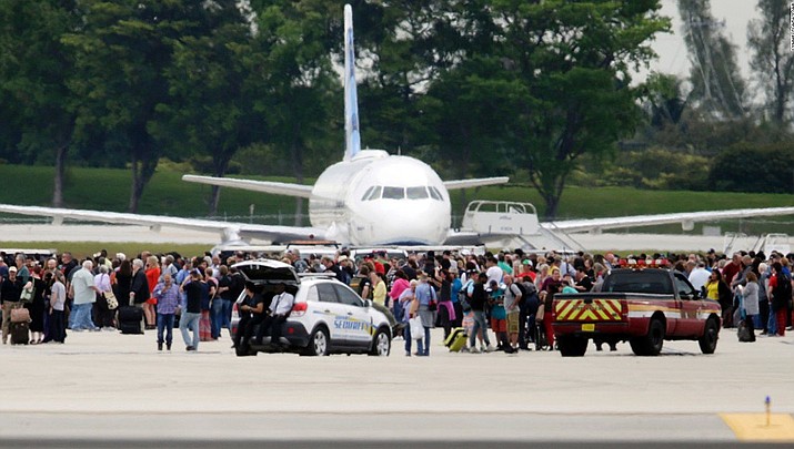 People stand on the tarmac at the Fort Lauderdale-Hollywood International Airport after a shooter opened fire inside a terminal of the airport, killing several people and wounding others before being taken into custody, Friday, Jan. 6, 2017, in Fort Lauderdale, Fla.