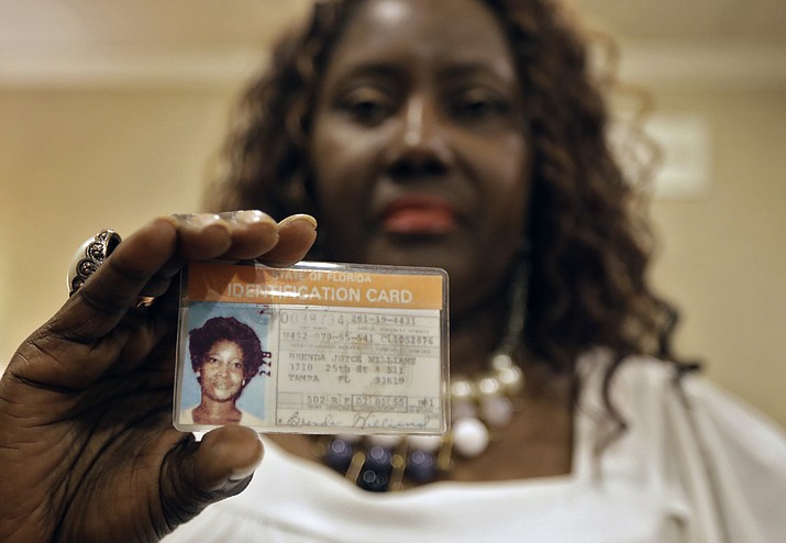 Sharon Scott poses for a photo with a Florida identification card for her missing sister Brenda Williams in Tampa, Fla. After decades of waiting to know what happened to their relative, Tampa Police officials told the family that they found a DNA match in a jawbone found in 1986. Williams, a young mother of two, went missing in 1978. (AP Photo/Chris O'Meara)

