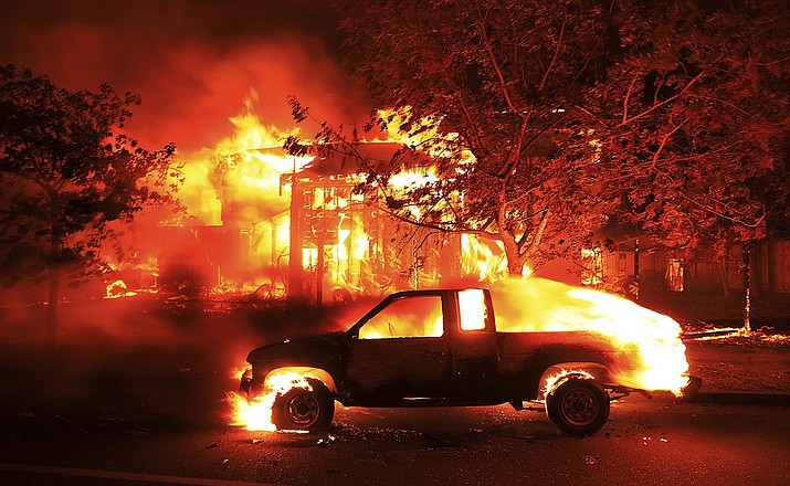 Coffey Park homes burn early Monday Oct. 9, 2017 in Santa Rosa, Calif. More than a dozen wildfires whipped by powerful winds been burning though California wine country. The flames have destroyed at least 1,500 homes and businesses and sent thousands of people fleeing. (Kent Porter/The Press Democrat via AP)