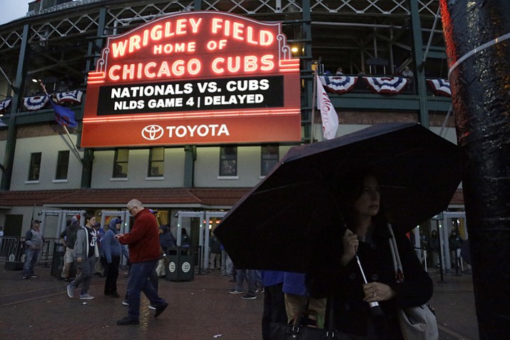 Fans leave Wrigley Field after Game 4 of baseball’s National League Division Series between the Chicago Cubs and the Washington Nationals was postponed due to rain Tuesday, Oct. 10, 2017, in Chicago. (Nam Y. Huh/AP)