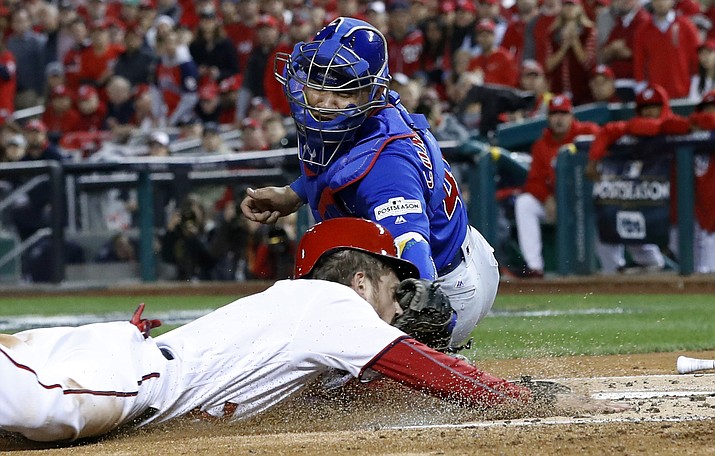 Chicago catcher Willson Contreras (40) tags out Washington’s Trea Turner (7) on a infield grounder by Bryce Harper in Game 5 of baseball’s National League Division Series, Thursday, Oct. 12, (Alex Brandon/AP)