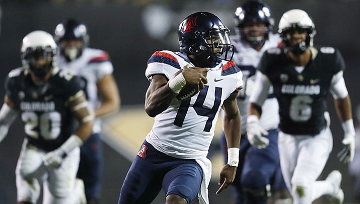 Arizona quarterback Khalil Tate, front, runs for a touchdown past Colorado linebacker Drew Lewis, back left, and defensive back Evan Worthington in the second half of an NCAA college football game Saturday, Oct. 7, 2017, in Boulder, Colo. Arizona won 45-42. (David Zalubowski/AP)