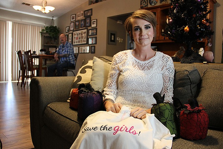 Shannon Fitzgerald is a breast cancer survivor. On her lap is a specially-designed t-shirt that was sold to help her get by financially during her treatments. Around her are homemade pumpkin decorations she enjoys making.  In the background is her father, who went through prostate cancer several years ago. (Max Efrein/Courier)