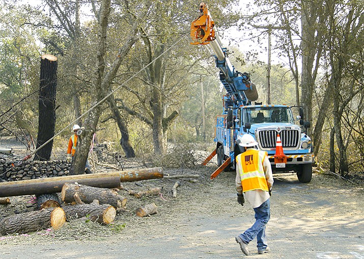 A Pacific Gas & Electric crew works on replacing poles Wednesday, Oct. 18, in Glen Ellen, California. Fire officials have reported significant progress on containing wildfires in northern California. (Ben Margot/AP)