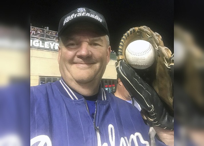 Los Angeles Dodgers fan Keith Hupp holds up the home run ball hit by Chicago Cubs’ Javier Baez in the second inning of Game 4 of baseballs National League Championship Series at Wrigley Field in Chicago, Wednesday, Oct. 18, 2017. (Keith Hupp via AP)