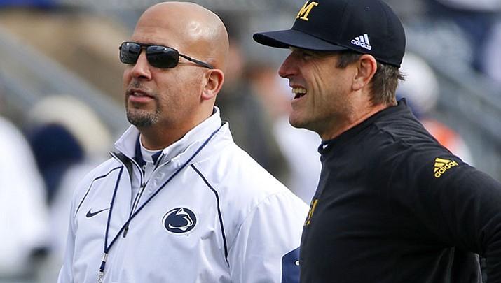 In this Nov. 21, 2015, file photo, Michigan head coach Jim Harbaugh, right, chats with Penn State head coach James Franklin before game in State College, Pa.