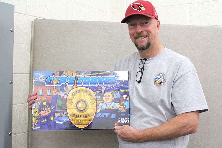 Paul Martin of Kingman shows the Cop’s Corner board game that he invented. 