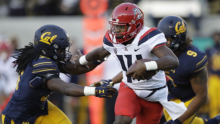 In this Saturday, Oct. 21, 2017, file photo, Arizona quarterback Khalil Tate, center, runs for a touchdown past California linebacker Alex Funches, left, during the first half of an NCAA college football game in Berkeley, Calif. Arizona's quarterback situation was resolved three games ago when Tate took over as starter. Other Pac-12 teams haven't had the same success in navigating mid-season QB quandaries. Injuries have impacted Oregon and Oregon State at the position.