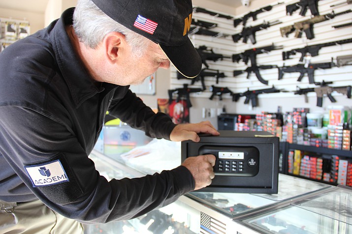 Donald Grier, manager of Prescott Gun Club, demonstrates how a small gun safe works. 