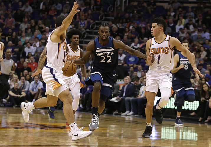 Minnesota Timberwolves forward Andrew Wiggins (22) drives between Phoenix Suns guard Mike James and Devin Booker (1) in the first half during an NBA basketball game, Saturday, Nov 11, in Phoenix. (Rick Scuteri/AP)
