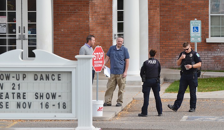 Police confer with officials at American Heritage Academy Wednesday after police dispatch received a call from a mother who said her daughter had texted her about a gunman at the school. American Heritage was having a lockdown drill at the time the call was made to police. VVN/Vyto Starinskas