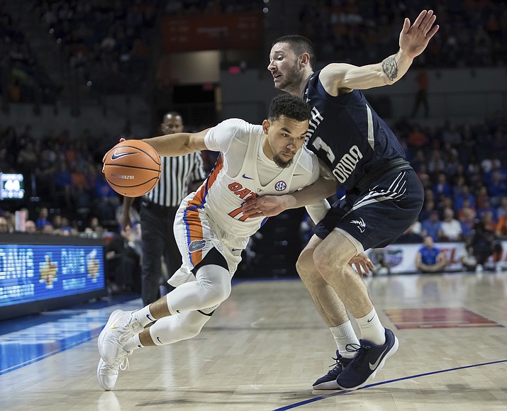 Florida guard Chris Chiozza (11) drives against the defense of North Florida guard J.T. Escobar (3) during the second half of an NCAA college basketball game in Gainesville, Fla., Thursday, Nov. 16, 2017. Florida won 108-68. (Ron Irby/AP)