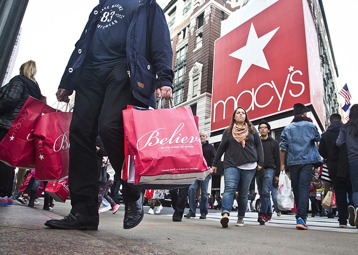 Shoppers carry bags as they cross a pedestrian walkway near Macy's in Herald Square, in New York. At Macy's flagship store in New York, a chance to sit on Santa Claus' lap is by appointment only in 2017, for the first time ever. (AP Photo/Bebeto Matthews, File)

