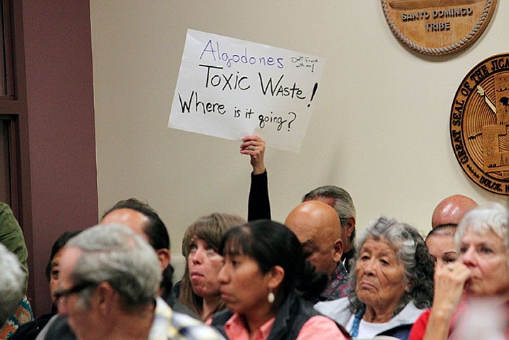 A protester holds up a sign in opposition to a proposed ordinance that would regulate oil and gas development in Sandoval County before the start of a County Commission meeting in Bernalillo, N.M., on Thursday. (AP Photo/Susan Montoya Bryan)