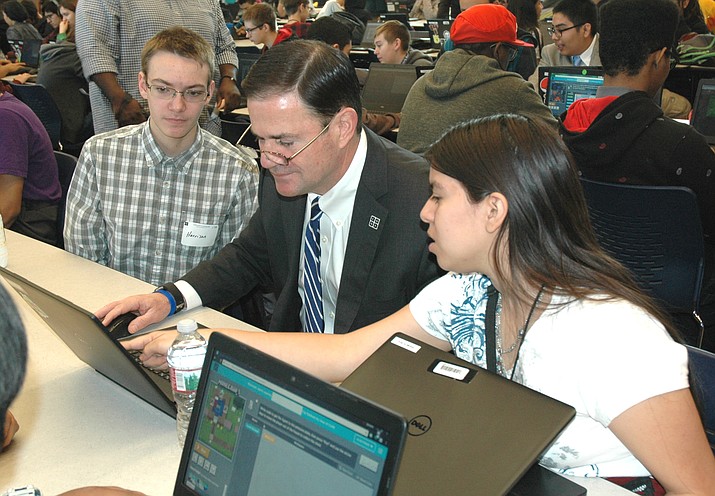 Harrison Kerkhoff and Eligia (Ellie) De La Cruz help Gov. Doug Ducey complete a coding task. Ducey visited the Phoenix Coding Academy Monday to praise what is being taught even though none of the funds came from the state.