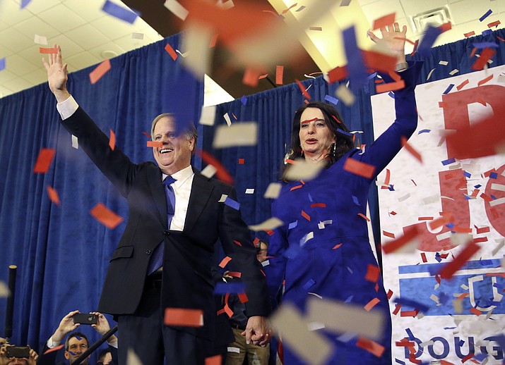 Democratic candidate for U.S. Senate Doug Jones and his wife Louise wave to supporters before speaking during an election-night watch party Tuesday, Dec. 12, 2017, in Birmingham, Ala. In a stunning victory aided by scandal, Democrat Doug Jones won Alabama's special Senate election on Tuesday, beating back history, an embattled Republican opponent and President Donald Trump, who urgently endorsed GOP rebel Roy Moore despite a litany of sexual misconduct allegations. (AP Photo/John Bazemore)