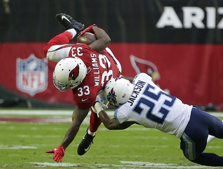 Arizona Cardinals running back Kerwynn Williams (33) gets upended by Tennessee Titans cornerback Adoree’ Jackson (25) during the second half of an NFL football game, Sunday, Dec.10, 2017, in Glendale. (Rick Scuteri/AP)