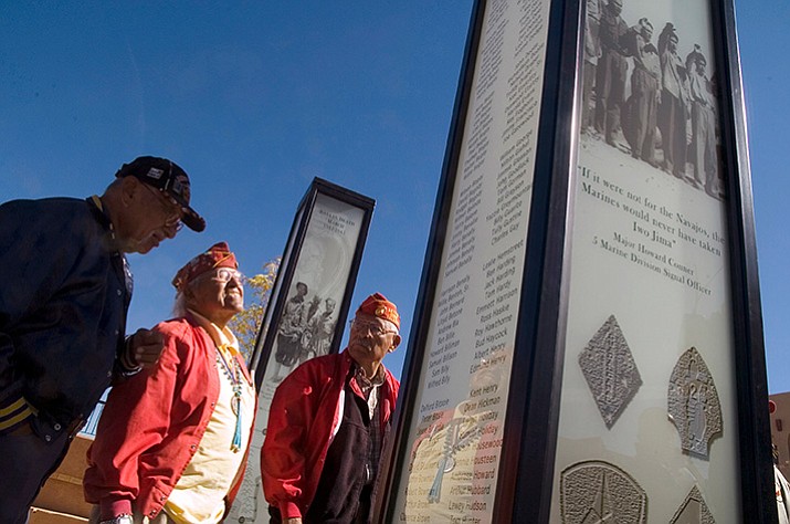 In this 2006 file photo, Navajo Code Talkers Albert Smith, Teddy Draper Sr., center, and Samuel Tso read the names of their brothers-in-arms written on a pillar dedicated to them during the filming of a documentary about them in Gallup, N.M. Navajo Nation officials said Draper died Thursday, Dec. 14, 2017, at age 96 in Prescott, Ariz. Draper resided in Chinle, Ariz. (AP, File)