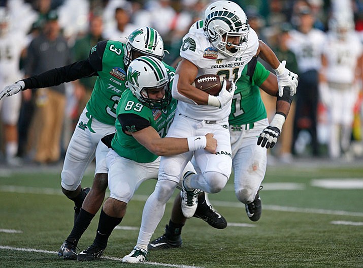 Colorado State wide receiver Olabisi Johnson (81) tries to elude Marshall long snapper Matt Beardall (89), defensive back Chris Jackson (3) and linebacker Chase Hancock (37) during the first half of the New Mexico Bowl NCAA college football game in Albuquerque, N.M., Saturday, Dec. 16, 2017. (Andres Leighton/AP)
