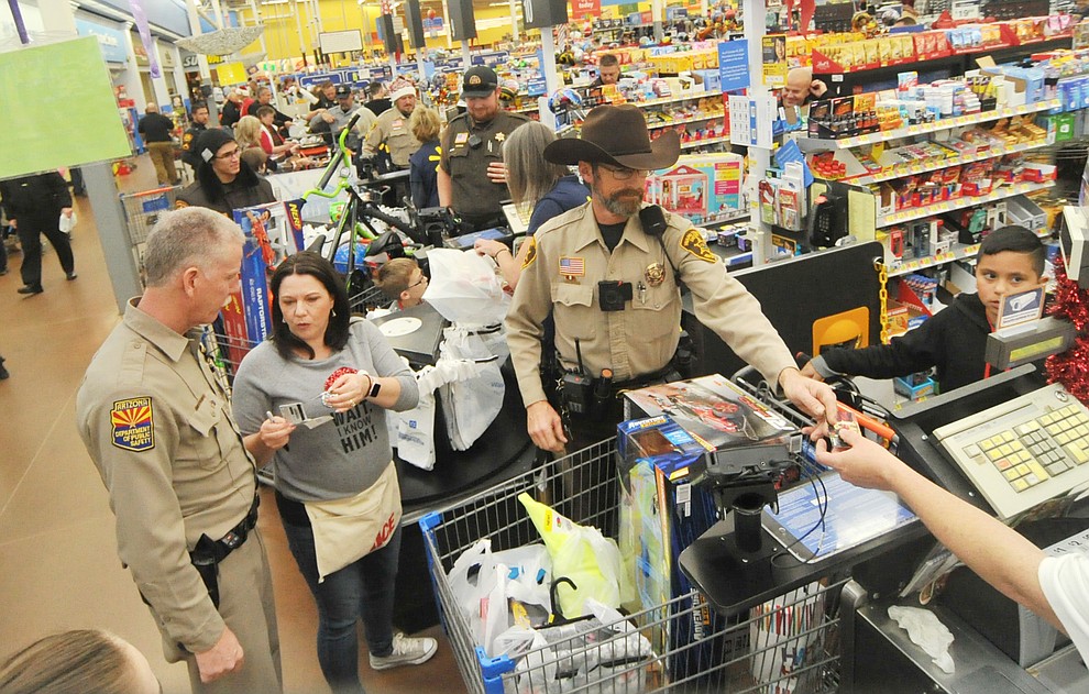 Shop with a Cop held their annual shopping spree for 115 children at the Walmart on Gail Gardner Way in Prescott Saturday morning. Officers from 12 local agencies took the children with $250 to spend shopping, then a breakfast, visit with Santa and a ride in their patrol vehicles. (Les Stukenberg/Courier)