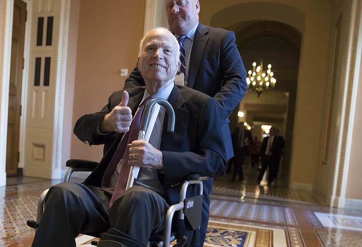 In this Dec. 1, file photo, Sen. John McCain, R-Ariz., leaves a closed-door session where Republican senators met on the GOP effort to overhaul the tax code, on Capitol Hill in Washington. President Donald Trump says McCain is returning home to Arizona after being hospitalized over the side effects from his brain cancer treatment. 