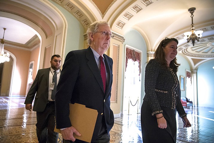 Senate Majority Leader Mitch McConnell, R-Ky., accompanied at right by Secretary for the Majority Laura Dove, walks to the chamber as Republicans in the House and Senate plan to pass the sweeping $1.5 trillion GOP tax bill on party-line votes, at the Capitol in Washington, Monday, Dec. 18, 2017. (AP Photo/J. Scott Applewhite)

