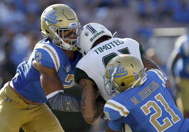 In this Sept. 9, 2017, file photo, Hawaii wide receiver Kalakaua Timoteo, center, drops the ball as he gets hit by UCLA linebacker Josh Woods, left, and defensive back Mossi Johnson (21) at the goal line, during the second half in Pasadena, Calif. Woods was penalized for targeting and ejected. (Alex Gallardo/AP, File)