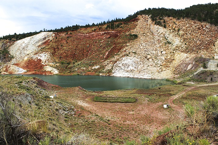 This photo shows the remaining pit at the Nacimiento Copper Mine near Cuba, N.M. The U.S. Forest Service has been working for years to clean up contaminated groundwater at the site, and now state Land Commissioner Aubrey Dunn has hired a consultant to review the site and determine what options exist for cleaning up tons of tailings made up of ore waste from past mining operations.  (AP Photo/Susan Montoya Bryan)

