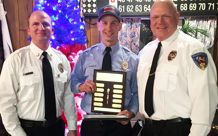 Williams Volunteer Fire Department Chief Chase Pearson and Asst. Fire Chief John Moede award Captain  Ryan Kopicky with the Firefighter of the Year award. 