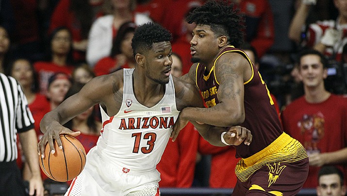 Arizona forward Deandre Ayton (13) works toward the basket as Arizona State’s Romello White defends during the first half of an NCAA college basketball game, Saturday, Dec. 30, 2017, in Tucson, Ariz.