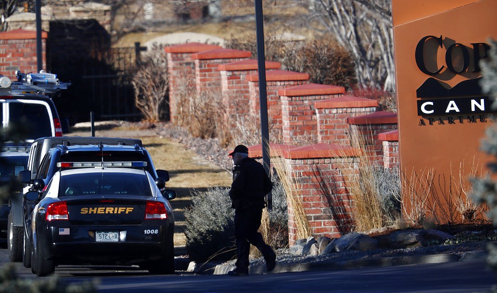 An investigator heads to the scene of shooting Sunday, Dec. 31, 2017, in Highlands Ranch, Colo. Authorities in Colorado say one deputy has died and multiple others were wounded, along with two civilians, in a shooting that followed a domestic disturbance in suburban Denver. (AP Photo/David Zalubowski)
