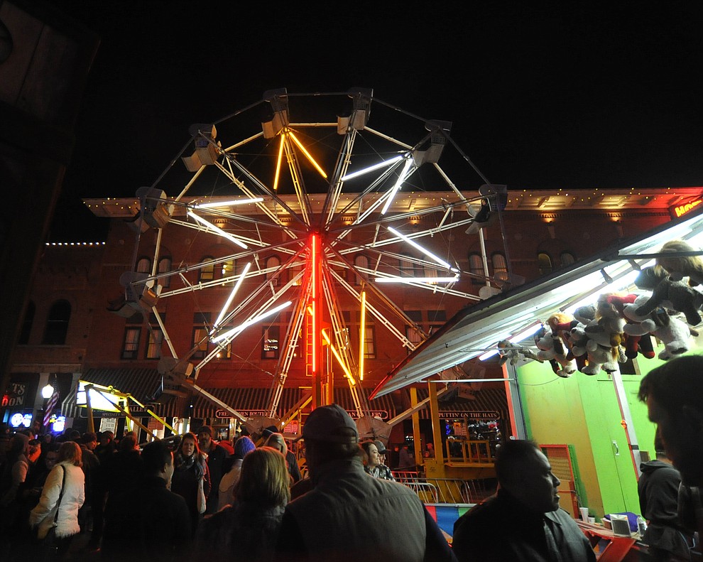 A ferris wheel takes people up and over Whiskey Row during the 7th annual New Year's eve Whiskey Row Boot Drop in Prescott Sunday night.  (Les Stukenberg/Courier)