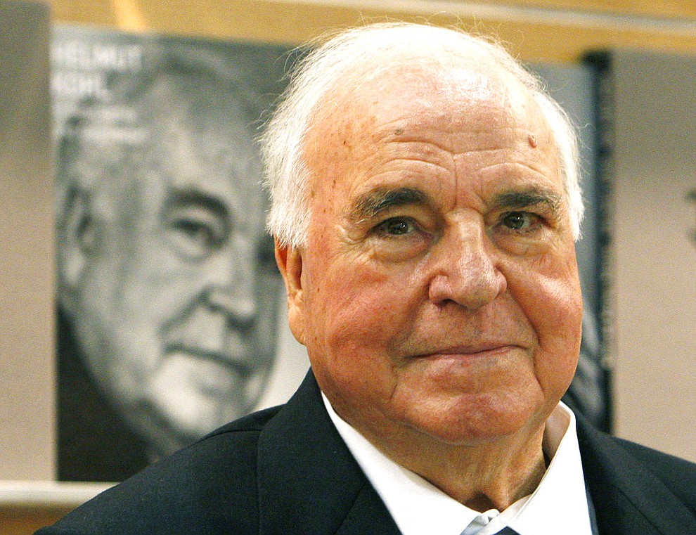 FILE - In this Oct. 8, 2010 file photo former German Chancellor Helmut Kohl talks to visitors and media about a picture book on him that was introduced at a book fair in Frankfurt, central Germany. Kohl, the German chancellor who reunited a nation divided by the Cold War and helped put Germany at the heart of a unified Europe, was among the political figures who died in 2017. (AP Photo/Michael Probst, File)