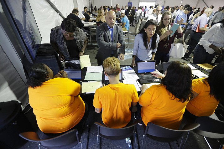 FILE - In this Wednesday, Aug. 2, 2017, file photo, job candidates are processed during a job fair at the Amazon fulfillment center in Robbinsville Township, N.J. On Friday, Jan. 5, 2018, the U.S. government issues the December jobs report. (AP Photo/Julio Cortez, File)

