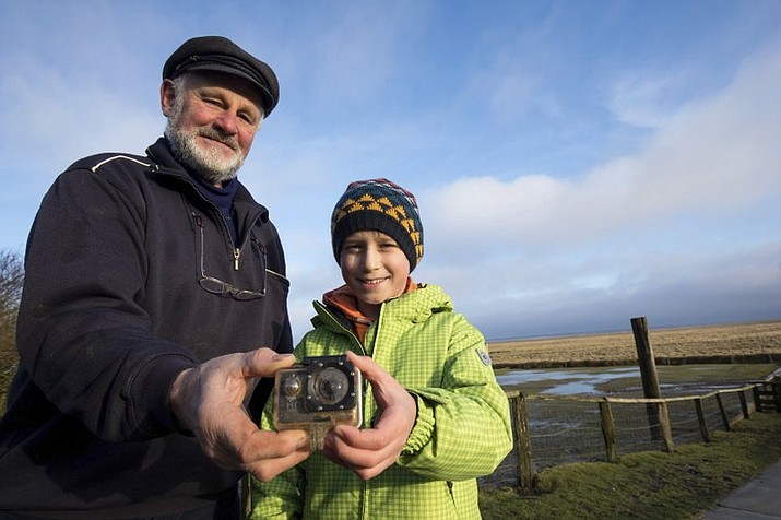 Britain’s William Etherton and resident Roland Spreer, hold a camera on the North Sea island of Suederoog, Germany. The English boy has been reunited in Germany with a video camera he lost four months ago on the other side of the North Sea. (Christian Charisius/dpa via AP)

