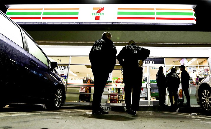 U.S. Immigration and Customs Enforcement agents serve an employment audit notice at a 7-Eleven convenience store Wednesday, Jan. 10, 2018, in Los Angeles. Agents said they targeted about 100 7-Eleven stores nationwide Wednesday to open employment audits and interview workers. (AP Photo/Chris Carlson)

