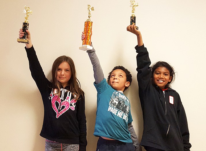 Williams Elementary-Middle School spelling bee winners Sierra Oswald (second place), Iscariot Rushing (first place) and Micka Davis Amasour (third place) accept their trophies. Rushing will advance to the Coconino County Spelling Bee in Flagstaff later this winter. 