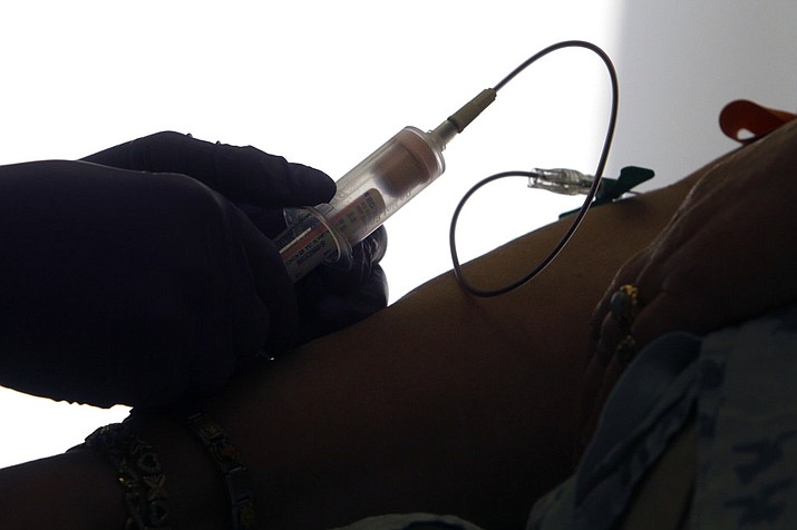 A patient has her blood drawn for a liquid biopsy at a hospital in Philadelphia. According to a report released Thursday, Jan. 18, 2018, scientists have made progress on a "liquid biopsy" test that can detect many types of cancer at an early stage from bits of DNA and other substances in blood. (AP Photo/Jacqueline Larma)
