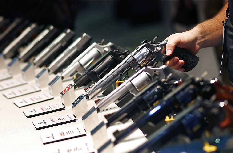 FILE - In this Jan. 19, 2016 file photo, handguns are displayed at the Smith & Wesson booth at the Shooting, Hunting and Outdoor Trade Show in Las Vegas. The largest gun industry trade show will be taking place in Las Vegas Jan. 23-26 just a few miles from where a gunman carried out the deadliest mass shooting in modern U.S. history. (AP Photo/John Locher, File)