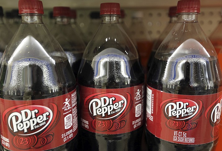 This April 28, 2016, file photo shows bottles of Dr. Pepper on a store shelf at Quality Cash Market in Concord, N.H. Keurig is buying Dr. Pepper Snapple Group Inc. to create a beverage business with approximately $11 billion in annual sales, announced Monday, Jan. 29, 2018. (AP Photo/Jim Cole, File)

