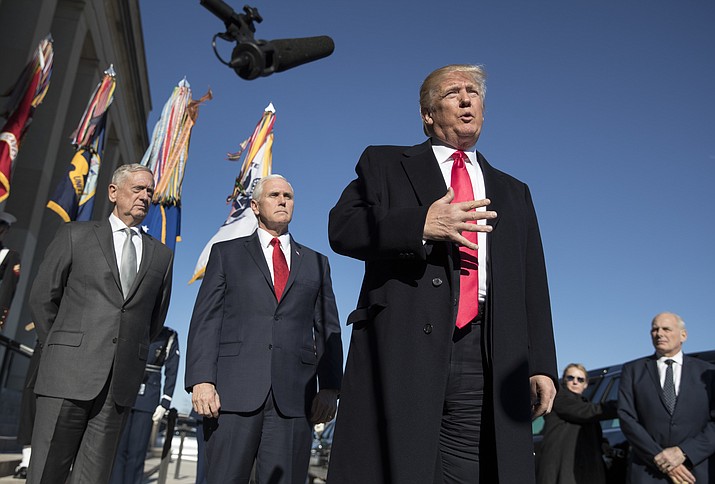 FILE - In this Jan. 18, 2018, file photo, President Donald Trump, joined by Defense Secretary Jim Mattis, left, Vice President Mike Pence, second from left, and White House Chief of Staff John Kelly, right, speaks to the media as he arrives at the Pentagon. When Jennifer Willoughby first stepped forward to tell the story how she was physically, emotionally and psychologically abused by her ex-husband, who had since become a top aide to President Donald Trump, the White House sent a clear message: We don't believe you. Instead, officials offered effusive support for her accuser. (AP Photo/Carolyn Kaster, File)

