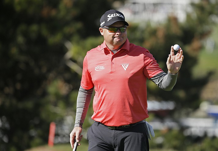 Ted Potter Jr. holds up his ball after making a birdie putt on the fourth green of the Pebble Beach Golf Links during the final round of the AT&T Pebble Beach National Pro-Am golf tournament Sunday, Feb. 11, in Pebble Beach, Calif. (Eric Risberg/AP)