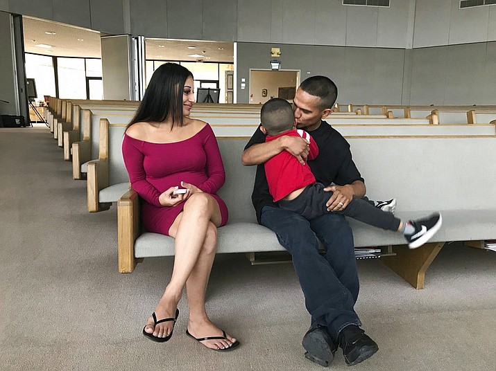 Jesus Berrones holds his five-year-old son, Jayden, as his wife, Sonia, looks on at the Shadow Rock United Church of Christ in Phoenix Monday, Feb. 12, 2018, where he has sought sanctuary to avoid deportation back to his native Mexico. (AP Photo/Anita Snow)