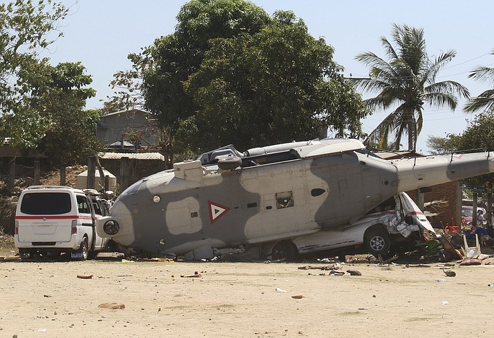 A downed helicopter lays in its side in Santiago Jimitepec, Oaxaca state, Mexico, Saturday, Feb. 17, 2018. The military helicopter carrying officials assessing damage from the Friday's earth quake crashed killing 13 people and injuring 15, all of them on the ground. (AP Photo/Luis Alberto Cruz Hernandez)

