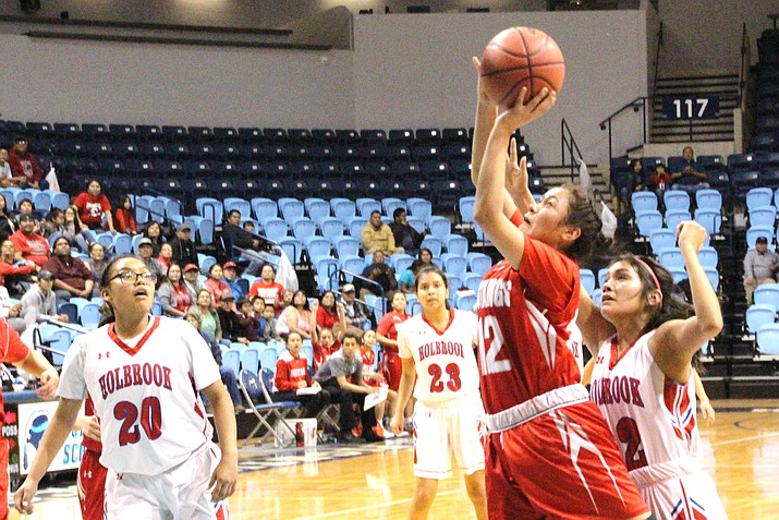 Monument Valley Lady Mustangs’ Tayla Nez drives in the paint past Holbrook’s Dakota Dick while Holbrook’s Megan Cummings, awaits for a possible rebound, during the 2018 Arizona AIA 3A State Girls Basketball Championship second round game. (Anton Wero/NHO)