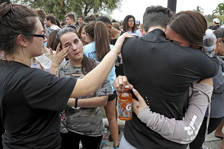 West Boca Raton Community High School students sophomore Leona Zaborsky, 16, right, and senior Julia Wheeler, 18, hug after reaching Marjory Stoneman Douglas High School in Parkland, Fla., Tuesday, Feb. 20, 2018. Hundreds of students walked out of the school Tuesday and made their way to the site of a school shooting about 10 miles (16 kilometers) away in a show of solidarity for bringing an end to gun violence. (Amy Beth Bennett/South Florida Sun-Sentinel via AP)