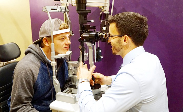 Dr. Jon Bundy, right, conducts an eye exam on Deiden Bennett, a local teen. Bundy, a doctor of optometry at Premier Eye Center in Prescott, fitted Bennett with special contact lenses to deal with his severe astigmatism. (Cindy Barks/Courier)